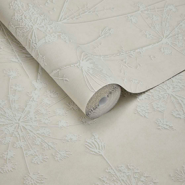 350511 Eijffinger Riviera Maison Silhouette Flowers - Dit behang is subtiel en natuurlijk met een beige achtergrond en een licht crèmekleurig bloemmotief in reliëf.